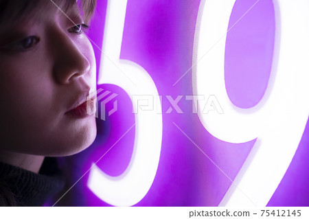 Woman illuminated by neon 75412145