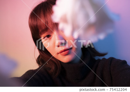 Woman with flowers in color light Woman with flowers in color light 75412204