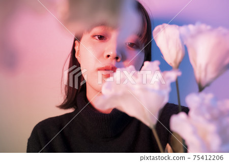 Woman with flowers in color light Woman with flowers in color light 75412206