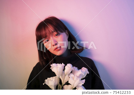 Woman with flowers in color light Woman with flowers in color light 75412233