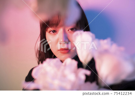 Woman with flowers in color light Woman with flowers in color light 75412234