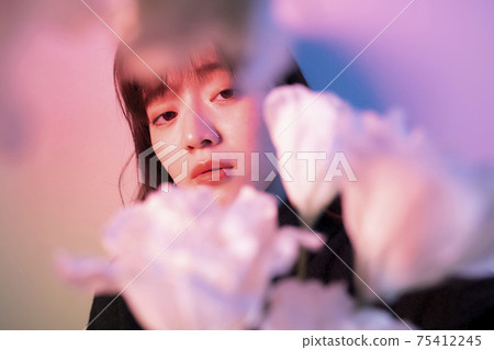 Woman with flowers in color light Woman with flowers in color light 75412245