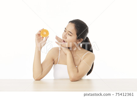 woman with sliced orange on white woman with sliced orange on white 75412361