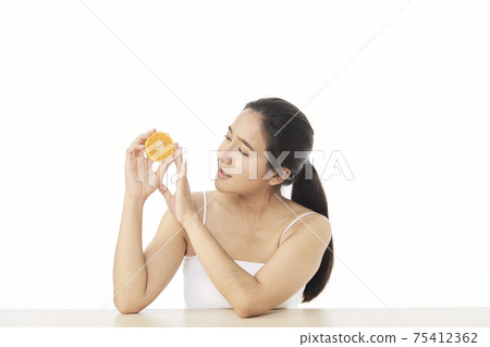 woman with sliced orange on white woman with sliced orange on white 75412362