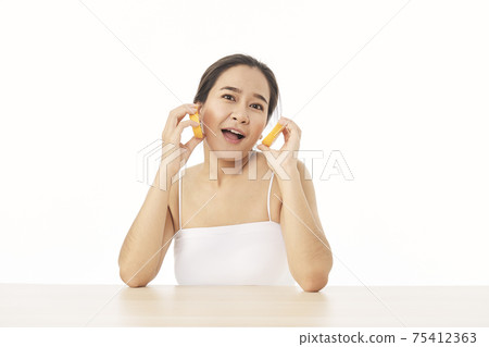 woman with sliced orange on white woman with sliced orange on white 75412363