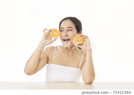 woman with sliced orange on white woman with sliced orange on white 75412364