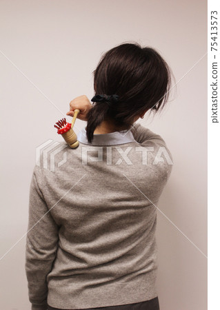 女人用錘子按摩肩膀 女人用錘子按摩肩膀 75413573