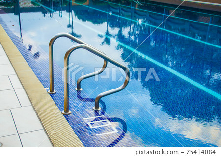 Swimming pool without people with metal handrails 75414084