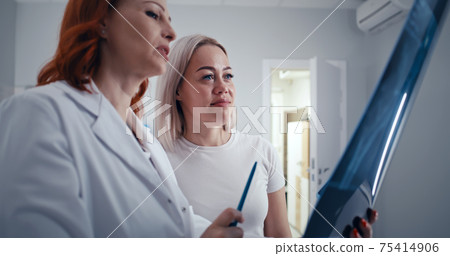 Mature doctor showing promising X ray results to patient 75414906