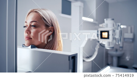 Mature doctor preparing female patient for chest X ray 75414919