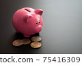 Bunch of valuable bitcoins placed near ceramic pink piggy bank on gray table 75416309