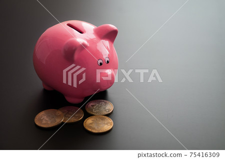 Bunch of valuable bitcoins placed near ceramic pink piggy bank on gray table 75416309
