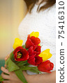 Soft focus of anonymous female carrying bunch of colorful fresh tulips during holiday celebration in spring 75416310