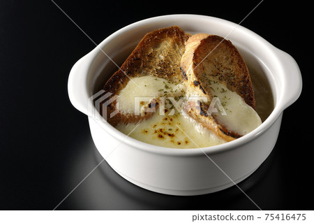Photographed onion soup with charred cheese and French bread on a black background Photographed onion soup with charred cheese and French bread on a black background 75416475