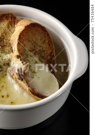 Photographed onion soup with charred cheese and French bread on a black background Photographed onion soup with charred cheese and French bread on a black background 75416484