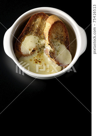拍攝的洋蔥湯，用焦燒的奶酪和法國麵包在黑色的背景（頂視圖） 75416513