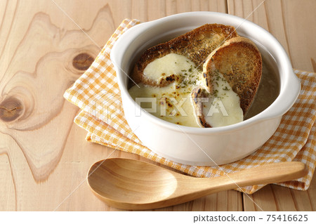 Burnt cheese, onion soup with French bread and a wooden spoon 75416625