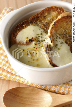 Burnt cheese, onion soup with French bread and a wooden spoon 75416630