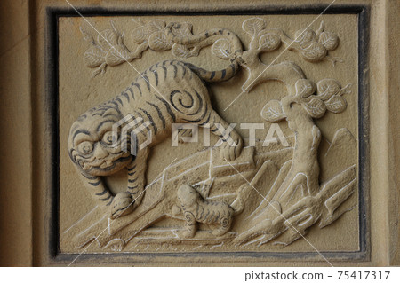Tiger stone carving style on wall of religious temple 75417317