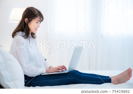 清晨在計算機上工作的年輕女子 75419802