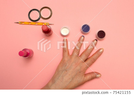 Manicure glitter and rub for nails. Tools on pink background top view flat lay. Manicure glitter and rub for nails. Tools on pink background top view flat lay. 75421155