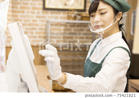Young woman cashier at a bakery 75421821