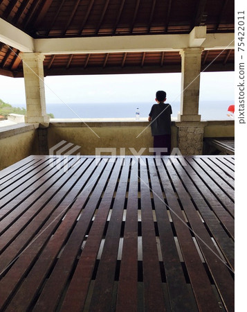 A boy standing at Uluwatu Temple 75422011