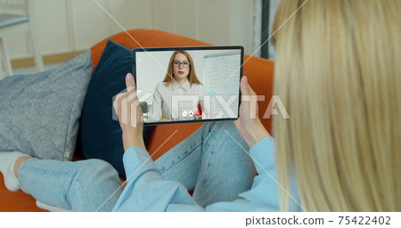 Female student study online and learns video lesson with teacher using tabletPC at home. E-learning classe, webinar, distance course or workshop concept at COVID-19 pandemic. 75422402
