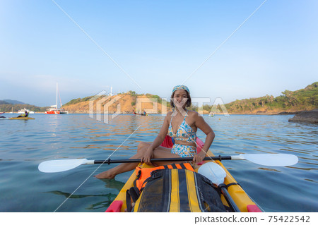 Women tourists wear bikinis and ride a canoe. Women tourists wear bikinis and ride a canoe. 75422542