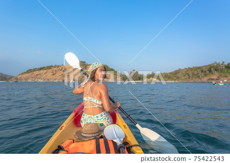 Women tourists wear bikinis and ride a canoe. Women tourists wear bikinis and ride a canoe. 75422543