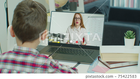 Child Little school Boy Kid schoolboy children using tablet laptop computer for homework at home, screen monitor. Distance education online learning lesson concept. Coronavirus COVID-19 quarantine. 75422583
