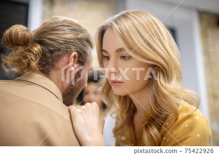 A girl sharing her secrets on the ear to her friend A girl sharing her secrets on the ear to her friend 75422926
