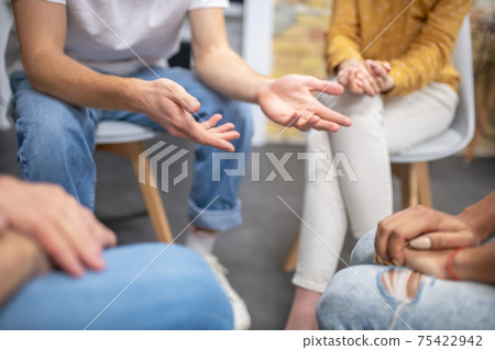 Close up picture of people sitting in a cirlce Close up picture of people sitting in a cirlce 75422942
