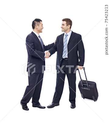 caucasian businessman with suitcase greeted by asian partner, isolated on white background caucasian businessman with suitcase greeted by asian partner, isolated on white background 75423213