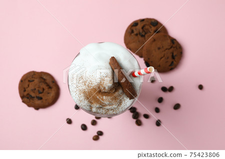 Glass of milkshake, coffee seeds and cookies on pink background 75423806