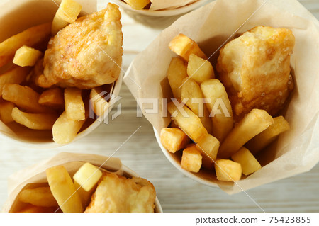 Paper cups with fried fish and chips on wooden background Paper cups with fried fish and chips on wooden background 75423855