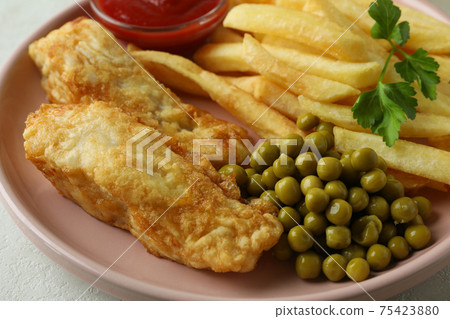 Plate with fried fish and chips, pea and ketchup, close up 75423880