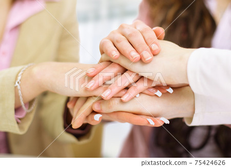 Image of business partners hands on top of each other symbolizing companionship and unity 75424626