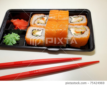Sushi rolls are Packed in plastic packaging close-up on an isolated background Sushi rolls are Packed in plastic packaging close-up on an isolated background 75424969