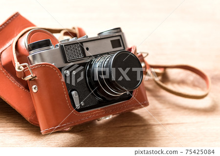Old vintage film slr photo camera in leather cover 75425084