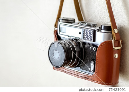 Old vintage film slr photo camera in leather cover 75425091