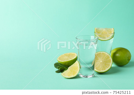 Shots, lime slices and mint on mint background Shots, lime slices and mint on mint background 75425211