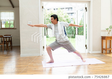 A man in his 60s enjoying yoga at home 75426867