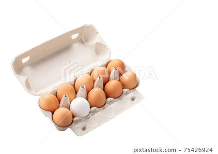 brown eggs and among them one white egg in carton box isolated. Concept of rejection, hostility, exclusion, exile. 75426924