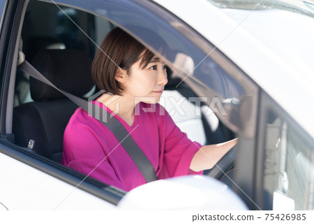 A young woman driving a car A young woman driving a car 75426985