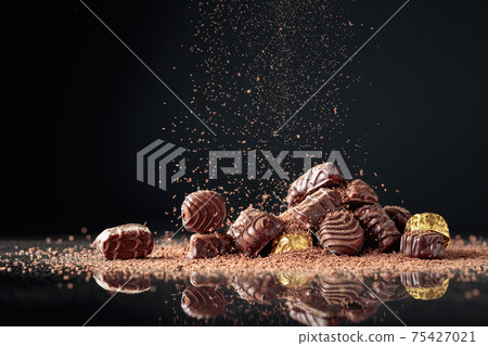 Chocolate candies sprinkled with chocolate chips. 75427021