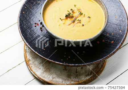 Tasty pumpkin creamy soup in bowl 75427304