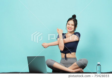 Fitness influencer. Sporty woman Blogger. workout training online via laptop. blue green background. Training woman KOL in sportswear shoots video exercise online. Exercises at home. notebook camera. 75428033