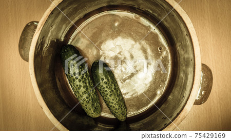 Making pickled cucumbers in clay jar 75429169