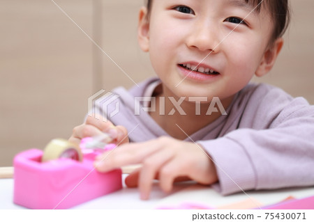 Girl who cuts and works on cellophane tape Girl who cuts and works on cellophane tape 75430071